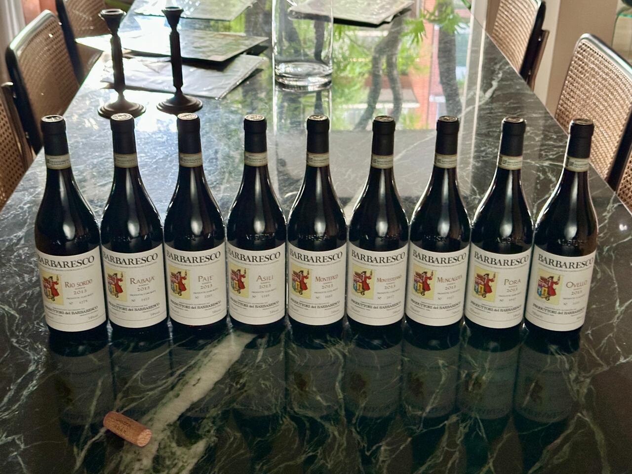 All nine 2013 Produttori del Barbaresco Crus on a marble table with a cork