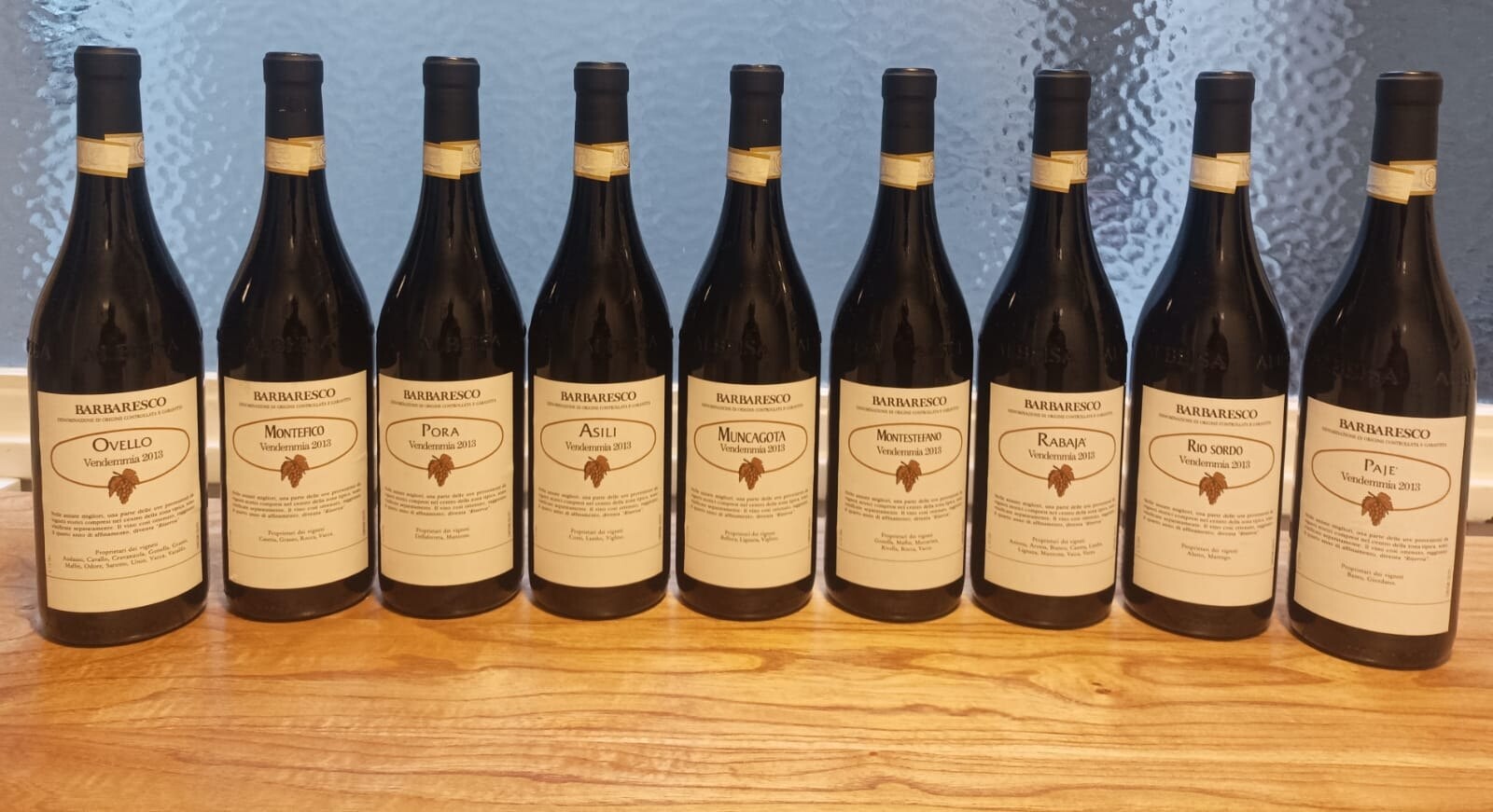 The nine 2013 Produttori del Barbaresco bottles showing the Vendemmia 2013 labels and vineyard owners